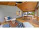 Relax on the wooden screened porch with ceiling fans, lounge furniture, dining table, and wooded views at 1895 Flat Shoals Se Rd, Atlanta, GA 30316