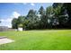 Large and green backyard featuring expansive lawn, mature trees and a storage shed at 2504 Hannah Haven Dr, Conyers, GA 30012