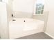 Bright bathroom features a large bathtub with tile surround and a window for natural light at 2504 Hannah Haven Dr, Conyers, GA 30012