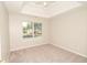 Bedroom with carpet, fan, modern trey ceiling, and view of front yard at 2504 Hannah Haven Dr, Conyers, GA 30012