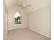 Bedroom featuring carpet, ceiling fan, and arched window with front yard view at 2504 Hannah Haven Dr, Conyers, GA 30012