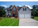 Charming two-story home featuring a manicured lawn, two-car garage, and classic architectural details at 2504 Hannah Haven Dr, Conyers, GA 30012