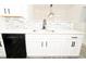 Modern kitchen featuring white cabinets, a stainless steel sink, quartz countertops, and black appliances at 2504 Hannah Haven Dr, Conyers, GA 30012