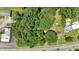 Aerial view of a wooded homesite, nearby a road with other houses and businesses, and swimming pool at 8587 Cumming Se Hwy, Canton, GA 30115