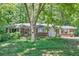 Charming single-story brick home with mature trees and a spacious front yard at 8587 Cumming Se Hwy, Canton, GA 30115