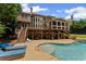 Expansive backyard with a swimming pool, covered deck, and mature trees, offering privacy and outdoor enjoyment at 3560 Greenside Ct, Dacula, GA 30019