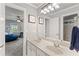 Bright bathroom featuring double sinks, framed art, and a glimpse into an adjacent bedroom with a beanbag chair at 3560 Greenside Ct, Dacula, GA 30019