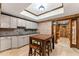 A basement dining area with a brick wall accent and a bar area with white cabinets at 3560 Greenside Ct, Dacula, GA 30019