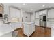 Well-lit kitchen with marble counters, white cabinets and stainless steel refrigerator at 3560 Greenside Ct, Dacula, GA 30019