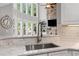Bright and open kitchen design with stainless steel sink, marble countertops and modern design at 3560 Greenside Ct, Dacula, GA 30019