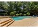 Backyard pool surrounded by mature trees and lounge chairs at 3560 Greenside Ct, Dacula, GA 30019