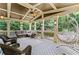 Relaxing screened porch with comfortable seating and a hanging swing at 3560 Greenside Ct, Dacula, GA 30019