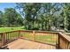 Enjoy serene wooded views from this home's wooden back deck and railing at 55 Forest Rd, Stockbridge, GA 30281