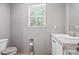 Bathroom featuring a modern toilet, vanity with a sink and a small window at 55 Forest Rd, Stockbridge, GA 30281