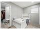 Relaxing bathroom featuring a soaking tub, built-in shelving, and a walk-in closet at 55 Forest Rd, Stockbridge, GA 30281
