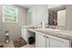 Bathroom with double sinks, modern mirrors, cabinets, and a small window at 55 Forest Rd, Stockbridge, GA 30281