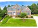 Charming brick home with a manicured lawn, complemented by lush green landscaping and mature trees at 917 Saints Ct, Marietta, GA 30068