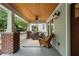 Inviting front porch with brick columns, wood ceiling, and cozy seating at 1066 High Point Dr, Atlanta, GA 30306