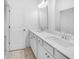 Bathroom featuring double sink vanity, modern fixtures and tan tile flooring at 5325 Trescott Path, Cumming, GA 30028