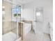 Bright bathroom featuring separate shower and tub with tan tile, and an open doorway to the bedroom at 5325 Trescott Path, Cumming, GA 30028