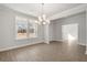 Dining room showcasing neutral decor, a modern chandelier, and large windows overlooking the front yard at 5325 Trescott Path, Cumming, GA 30028