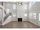 Open-concept living room with fireplace, large windows, and a staircase leading to the second floor at 5325 Trescott Path, Cumming, GA 30028