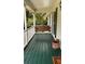 Inviting porch with a swing and a green painted wood floor at 5904 Clairmont Way, Powder Springs, GA 30127