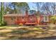 View of the brick home exterior, deck, and large backyard at 9491 Hidden Branch Dr, Jonesboro, GA 30236