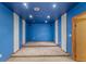 Finished basement with tiered carpeted platform and colorful walls at 9491 Hidden Branch Dr, Jonesboro, GA 30236