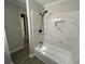 Updated bathroom with a shower-tub combination and marbled tile at 9491 Hidden Branch Dr, Jonesboro, GA 30236