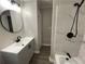 Modern bathroom with black hardware, grey vanity, and tub/shower combo at 9491 Hidden Branch Dr, Jonesboro, GA 30236