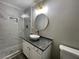 Bathroom with marble-look tiled shower, white vessel sink, and granite countertop at 9491 Hidden Branch Dr, Jonesboro, GA 30236