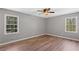 Bright bedroom with natural light showcasing two windows and hardwood flooring at 9491 Hidden Branch Dr, Jonesboro, GA 30236