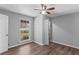 Cozy bedroom with wood-look floors, a ceiling fan, and a window at 9491 Hidden Branch Dr, Jonesboro, GA 30236