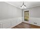 Dining room featuring decorative trim, a modern light fixture, and updated flooring at 9491 Hidden Branch Dr, Jonesboro, GA 30236