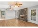 Cozy living room featuring a stone fireplace, wood floors, and abundant natural light at 9491 Hidden Branch Dr, Jonesboro, GA 30236