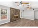 Cozy living room featuring a stone fireplace, wood floors, and abundant natural light at 9491 Hidden Branch Dr, Jonesboro, GA 30236