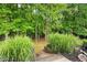 Wooden steps lead down to a secluded yard framed by mature trees and lush greenery creating a peaceful and private retreat at 1811 Ascot Nw Cv, Acworth, GA 30102
