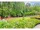 A beautifully landscaped backyard features colorful flowers, lush greenery, and a serene, private setting at 1811 Ascot Nw Cv, Acworth, GA 30102