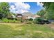 A home surrounded by a lush, green backyard is complete with a pool, patio, and abundant landscaping at 1811 Ascot Nw Cv, Acworth, GA 30102