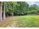 Expansive grassy backyard bordered by mature trees and a wooden fence offering privacy and plenty of room for outdoor activities at 1811 Ascot Nw Cv, Acworth, GA 30102