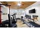 This basement has been converted into a home gym with workout equipment and a wall-mounted TV at 1811 Ascot Nw Cv, Acworth, GA 30102