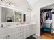 Bathroom featuring double vanity, a large mirror, and an adjacent walk-in closet at 1811 Ascot Nw Cv, Acworth, GA 30102
