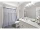 This bathroom features a large mirror, vanity, and a shower with a modern gray shower curtain at 1811 Ascot Nw Cv, Acworth, GA 30102
