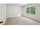Bedroom with neutral carpeting and a large window letting in natural light, creating a calming atmosphere at 3159 Stonegate Sw Dr, Atlanta, GA 30331