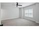Bright bedroom featuring neutral carpet, ceiling fan, and large window at 3159 Stonegate Sw Dr, Atlanta, GA 30331