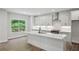 Modern kitchen with white cabinets, a quartz island, stainless steel appliances, and a window overlooking the serene backyard at 3159 Stonegate Sw Dr, Atlanta, GA 30331
