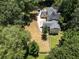 Aerial view of property featuring a well-maintained lawn, mature trees, and a home in a lush, green setting at 6380 Concord Rd, Cumming, GA 30028