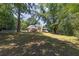 Large backyard featuring a well-manicured lawn, a deck, and mature trees, offering privacy and space at 6380 Concord Rd, Cumming, GA 30028