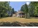 Expansive backyard featuring a well-maintained lawn, a deck, and mature trees, providing ample space at 6380 Concord Rd, Cumming, GA 30028